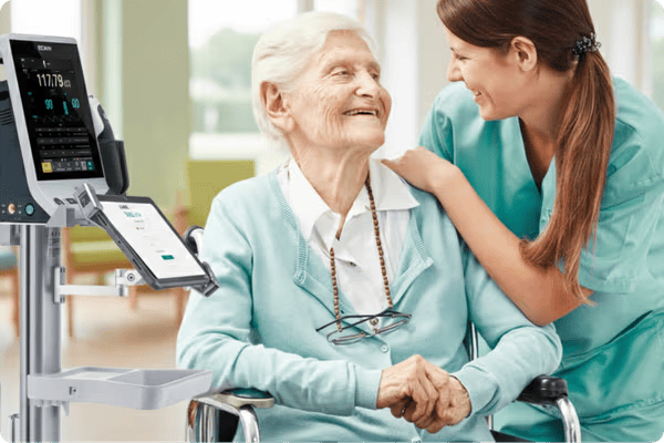 Nurse using VitalLink point-of-care software on tablet at patient side