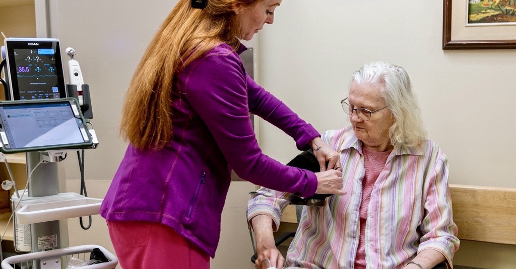 A nurse taking a resident's blood pressure with VitalLink at Glen Hill Strathaven long-term care home.